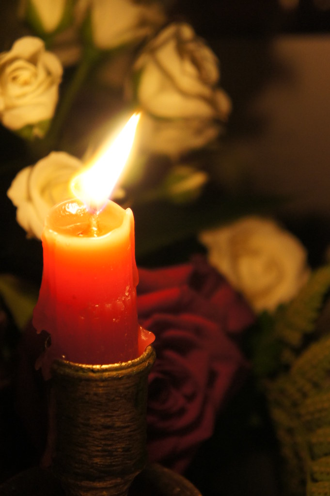 Vela encendida entre rosas en una boda